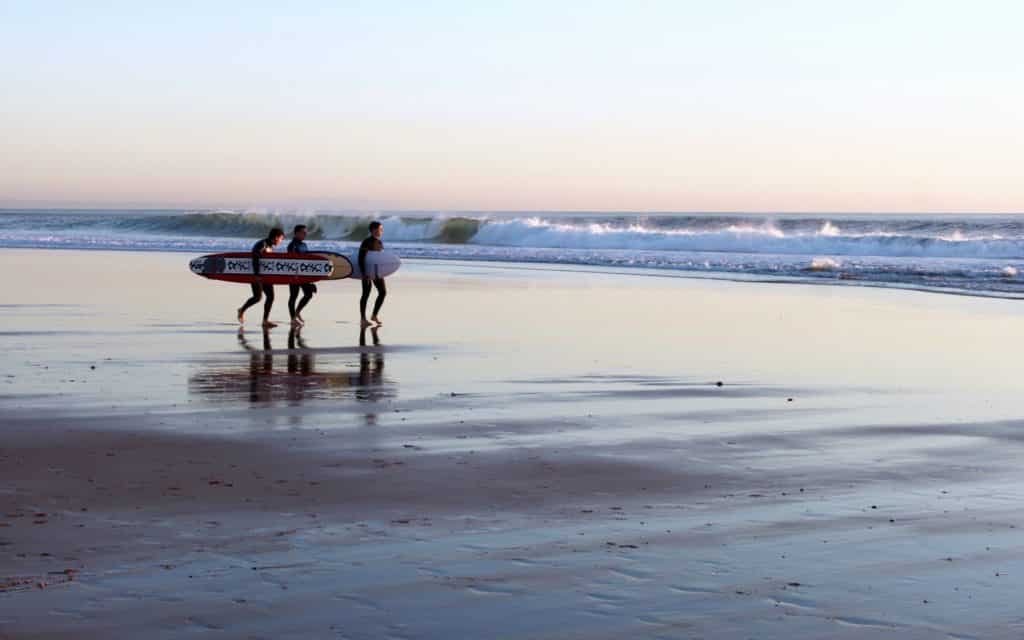 Surfers walking along the beach in Portugal